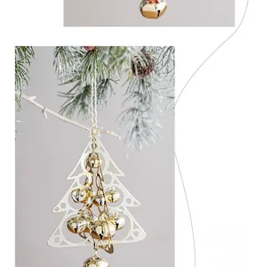 White Christmas tree frame with gold bells hanging on snowy pine branches