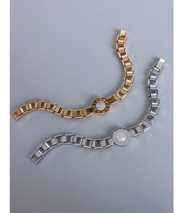Close-up of gold and silver Roman numeral bracelets with mother of pearl inlay