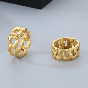 Macro detail of two golden Cuban chain rings in stainless steel with polished finish