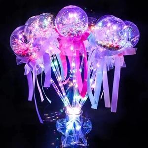 Close-up of glowing LED bobo ball bouquet with colorful beads and pink ribbons in star bottle
