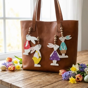Brown leather tote bag with four colorful wooden rabbit charms and spring floral decor