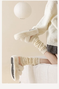 Gros plan de jambières en tricot blanc avec des chaussons en fausse fourrure douce