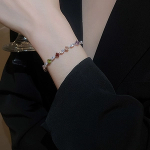 Detail of colorful zircon gemstone bracelet on wrist with elegant gold-plated settings