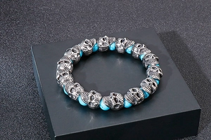 Detailed close-up of retro punk skull beads and sky blue turquoise stone on a steel bracelet