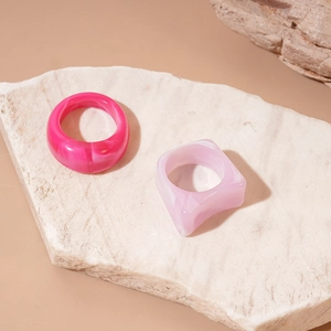 Detail of pink marble acrylic rings in round and square shapes on marble stone