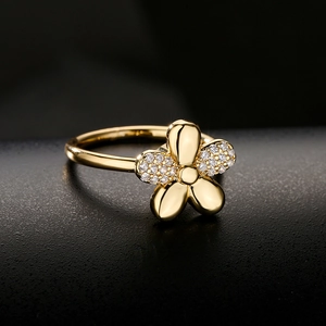 18K gold flower ring with micro-set zircons and polished petals on a dark base