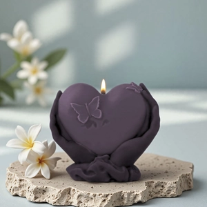Vela aromática de corazón con grabado de mariposa sobre un pedestal de piedra