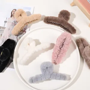 Detail view of various large plush claw clips in neutral colors on a white plate
