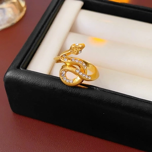 Detailed close-up of gold plated snake ring with white zircon pave setting on leather box