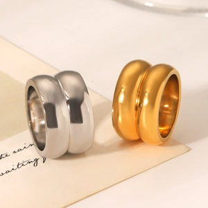 Close-up of dual-layer minimalist rings in gold and silver finishes on background