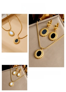 Détail de la parure en acier inoxydable doré avec pendentifs ovales noirs et blancs