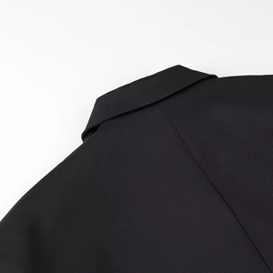 Detailed close-up of the notched lapel and padded shoulder of the black oversized blazer
