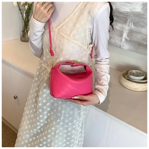 Detail of pink PU leather handbag with rich rabbit embossing and metal buckle