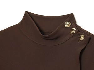 Détail du col montant sur robe marron avec trois boutons dorés métalliques irréguliers