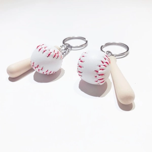 Detail view of mini baseball keychain featuring white ball with red stitching and wooden bat