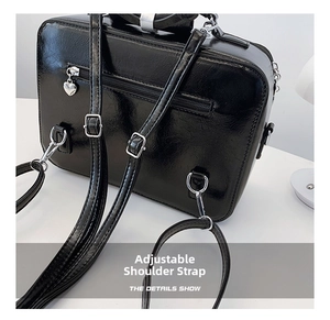Detail of adjustable straps and heart-shaped zipper on black leather backpack
