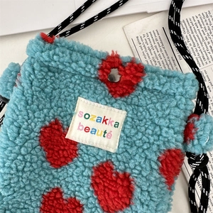 Detail of blue plush heart bag with adjustable strap and sozakka beauté woven label