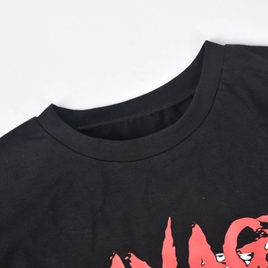 Détail du col rond et de l'imprimé graphique 'SAVAGE' rouge sur un t-shirt en coton noir