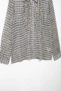 Detail of elegant ruffled collar and geometric print on lightweight chiffon blouse