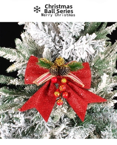 Detail of red glitter Christmas bow with pine cones and berries on a snowy tree