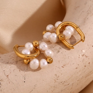 Détail de boucles d'oreilles en U plaquées or 18K avec perles d'eau douce sur socle