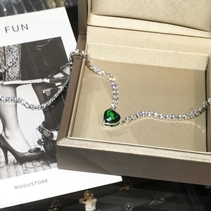 Detailopname van luxe hartketting met groene steen en fonkelende tennis ketting