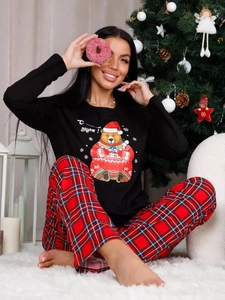 Detailed view of Christmas pajama set with bear print top and plaid pants in a festive room