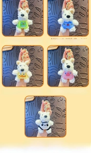 Close-up of West Highland Terrier plush keychains in colorful animal costumes with gold clips