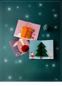 Flat lay of 3D Christmas pop-up greeting cards with reindeer and tree designs