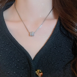 Close-up of model wearing a silver multilayer cubic zirconia cylinder pendant necklace