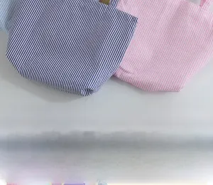Detail showing various striped seersucker fabrics in navy, pink, and light blue colors
