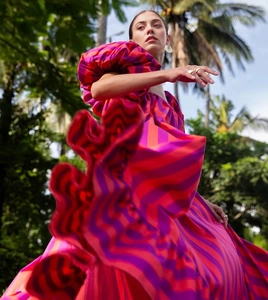 Dynamic low-angle shot of a striped puff-sleeve maxi dress with a voluminous orange skirt