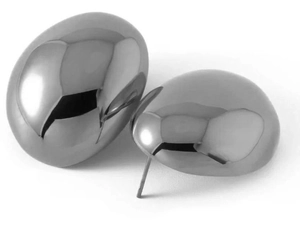 Detailed close-up of chunky silver oval stud earrings with smooth mirror finish