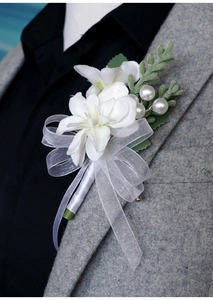 Close-up of a white wedding boutonniere with pearls on a grey tweed suit lapel