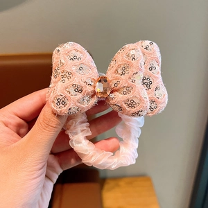 Detail of pink bow hair tie with silver sequins and amber gemstone for girls