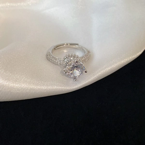 Macro shot of silver ring with large round zircon, pavé diamonds, and adjustable band