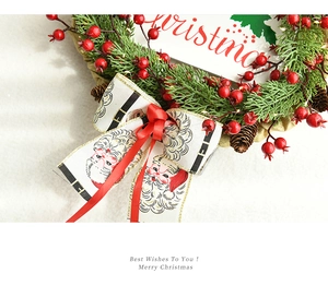 Close-up of Christmas wreath with pine needles, red berries, and Santa printed ribbon