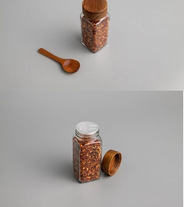Detail of glass spice jar with acacia wood lid, wooden spoon and internal metal sifter