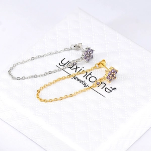 Detail of flower stud earrings with purple zircon and long chain tassels in gold and silver