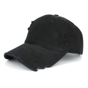 Close-up of distressed ripped details on a black cotton canvas baseball cap