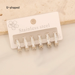 Macro view of three pairs of U-shaped stainless steel earrings with sparkling zircon