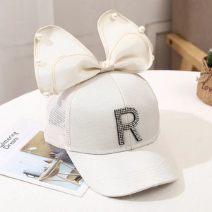 Detail of white mesh baseball cap with pearl bow and rhinestone letter R decoration