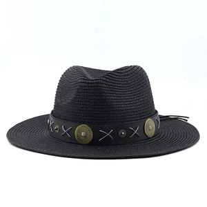 Close-up of black bohemian straw fedora with vintage brass studded leather band