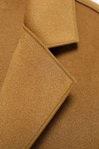 Macro shot of camel wool coat collar showing premium texture and neat stitching details