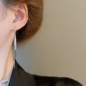 Close-up of silver tassel earrings with teardrop cubic zirconia on a model side view