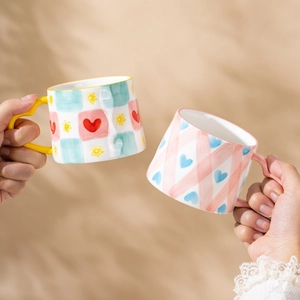 Cute hand-painted ceramic mugs with hearts and checkered pattern for coffee time