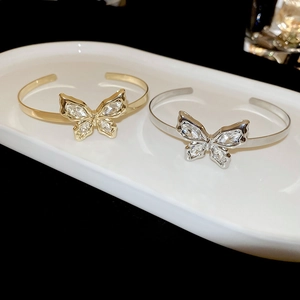 Detailed comparison of gold and silver butterfly open bracelets with sparkling zircons