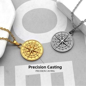 Detailed macro view of gold and silver compass pendants with engraved N S E W directional marks