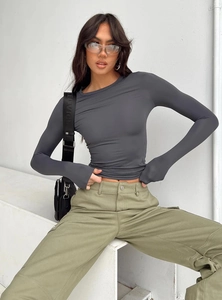 Close-up of slim fit dark grey long sleeve top paired with olive green cargo pants