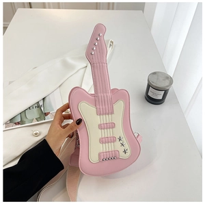 Close-up of pink guitar-shaped crossbody bag with metal stars and wide canvas strap